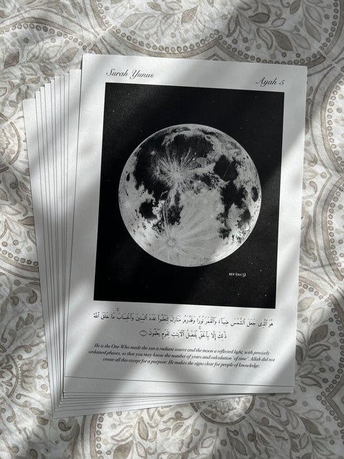 Stack of minimalistic islamic prints depicting the verse (10:5) with a monochrome full moon on a black background. Below is the verse it is inspired by. The perfect reminder and decor for any muslim.